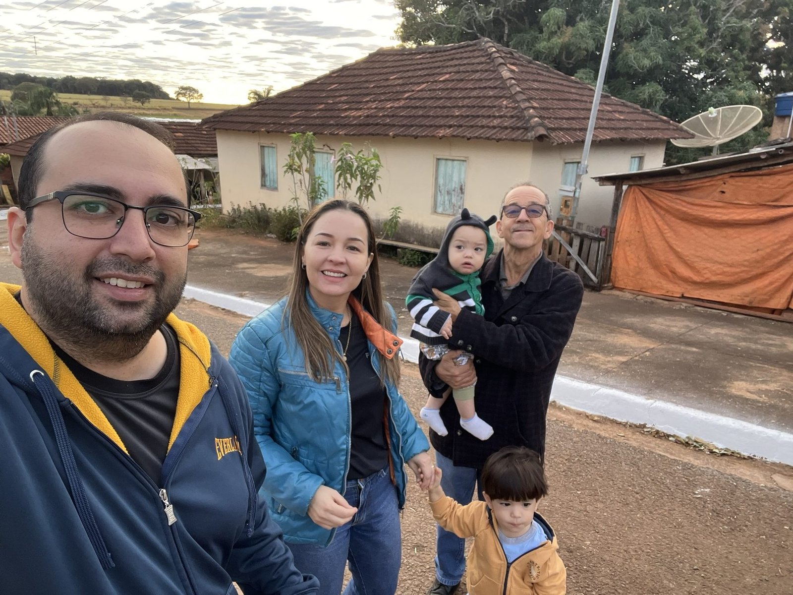 Família reunida em frente a uma casa no interior