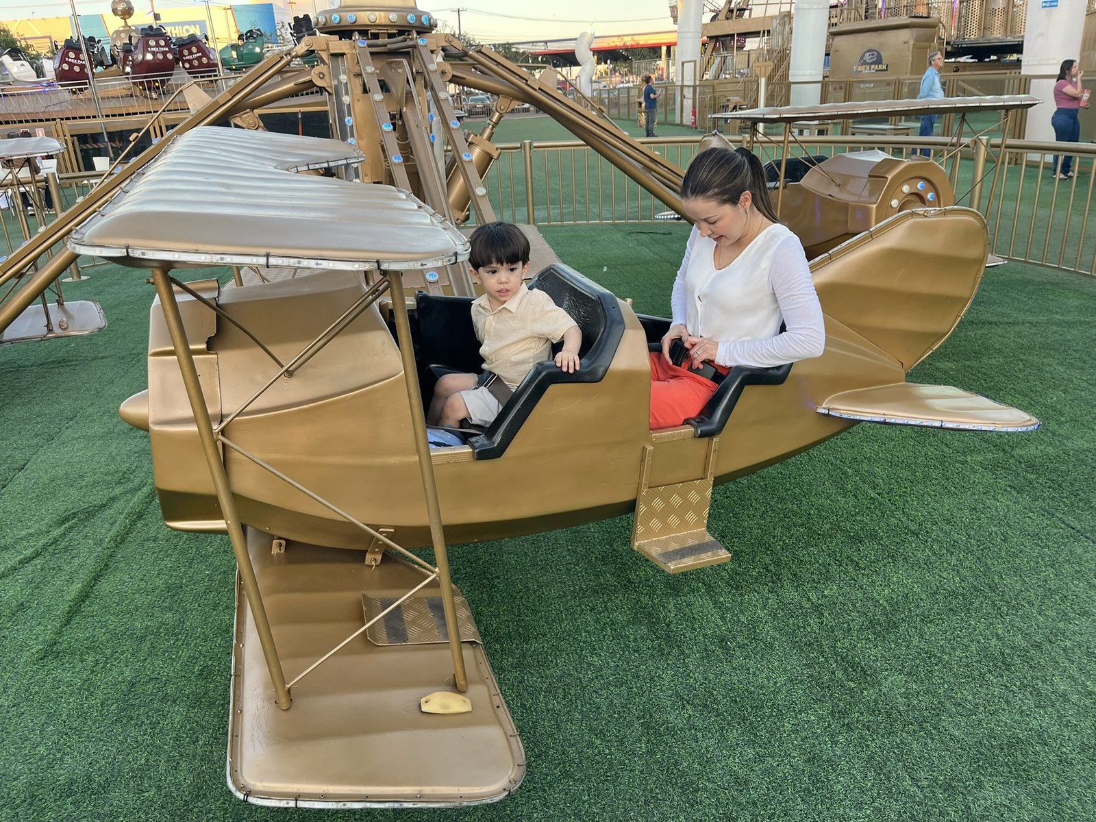 Nordana e um dos meninos em um brinquedo em forma de avião